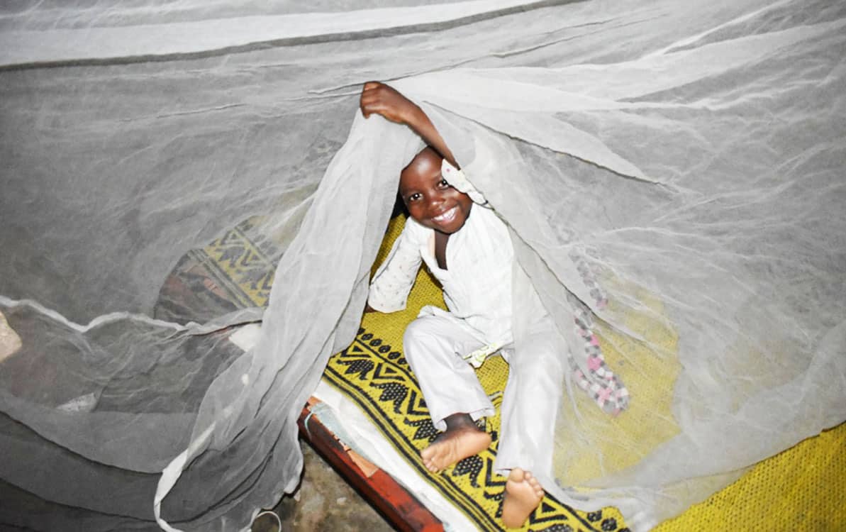 A mother and child beneath a mosquito net